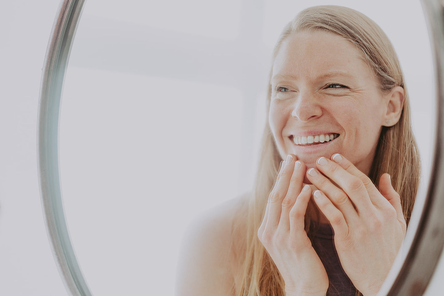 An overhead view of a yoga practice - a woman in downward dog is photographed from above with the foot in focus on her yoga mat.