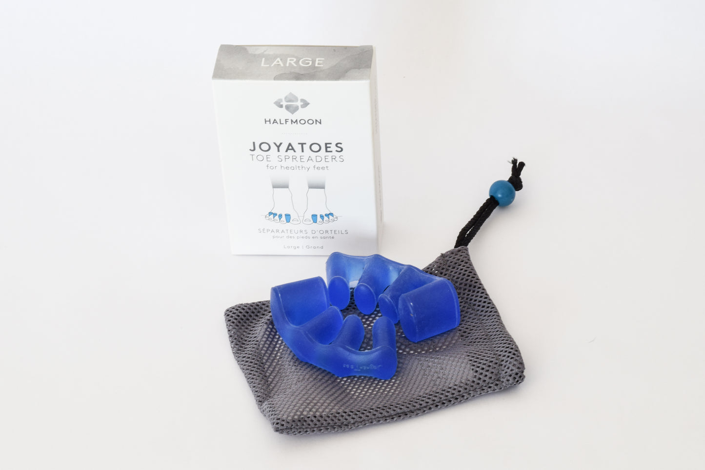 Joy-a-toes toe spacers - shown as blue silicone gel spacers on a mesh carrying bag with the clean white Joy-a-toe box on the background.
