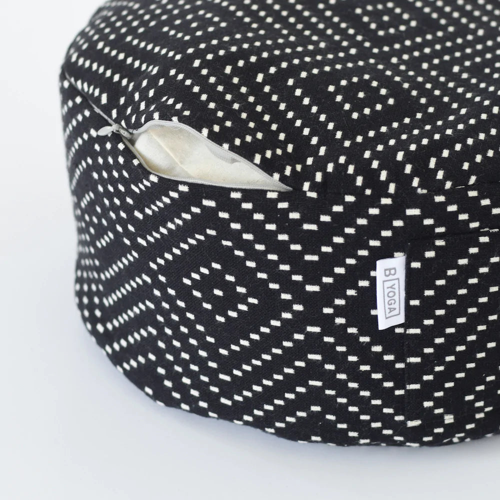 The Calm Meditation Cushion - Modern City Night (black and white diamond pattern white spots on a black round meditation cushion) photographed on a white background - close up with zipper open to show easy cleaning of cover.