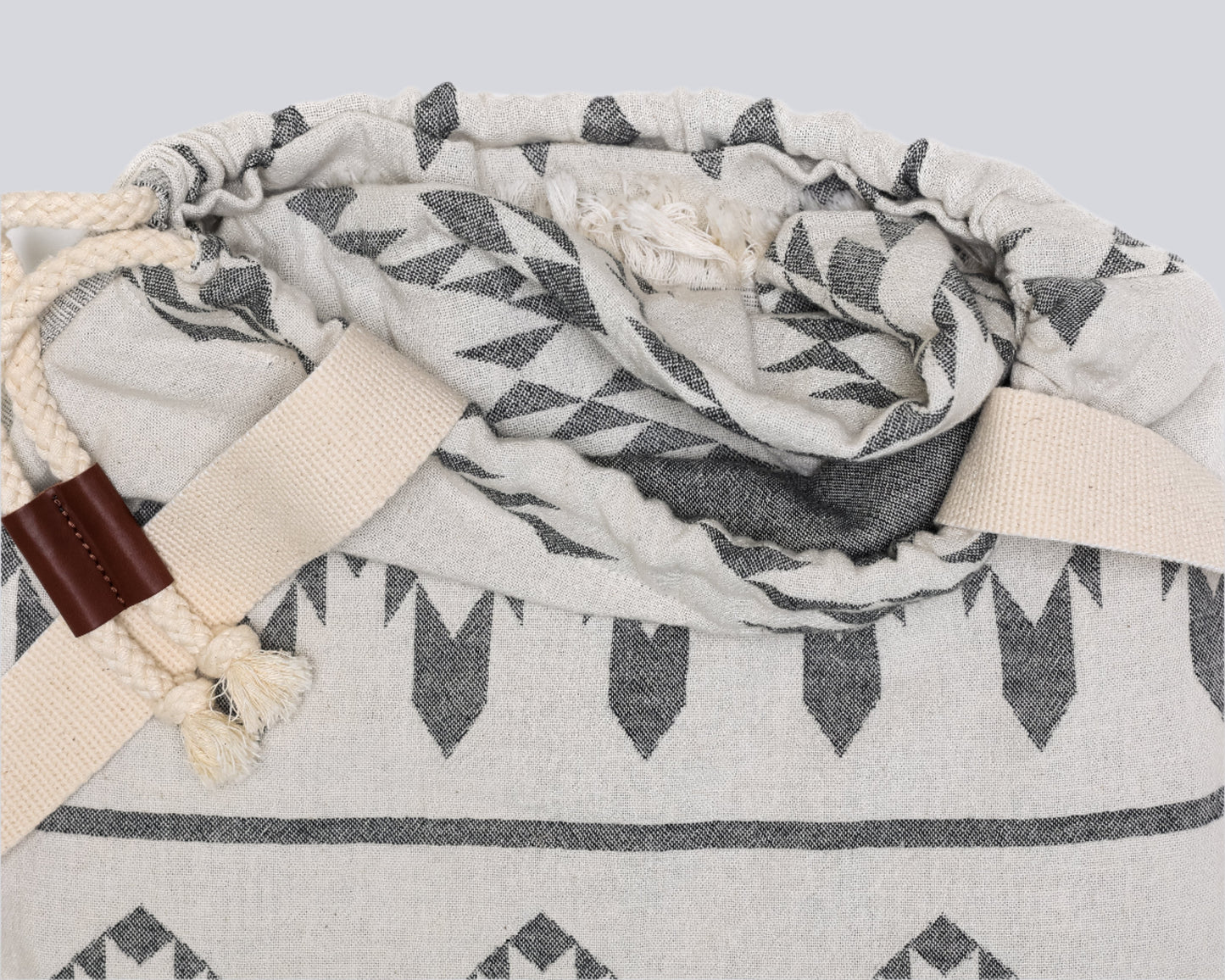 Opening of backpack/towel of - The Day Tripper Towel in Granite colour - on a white backdrop