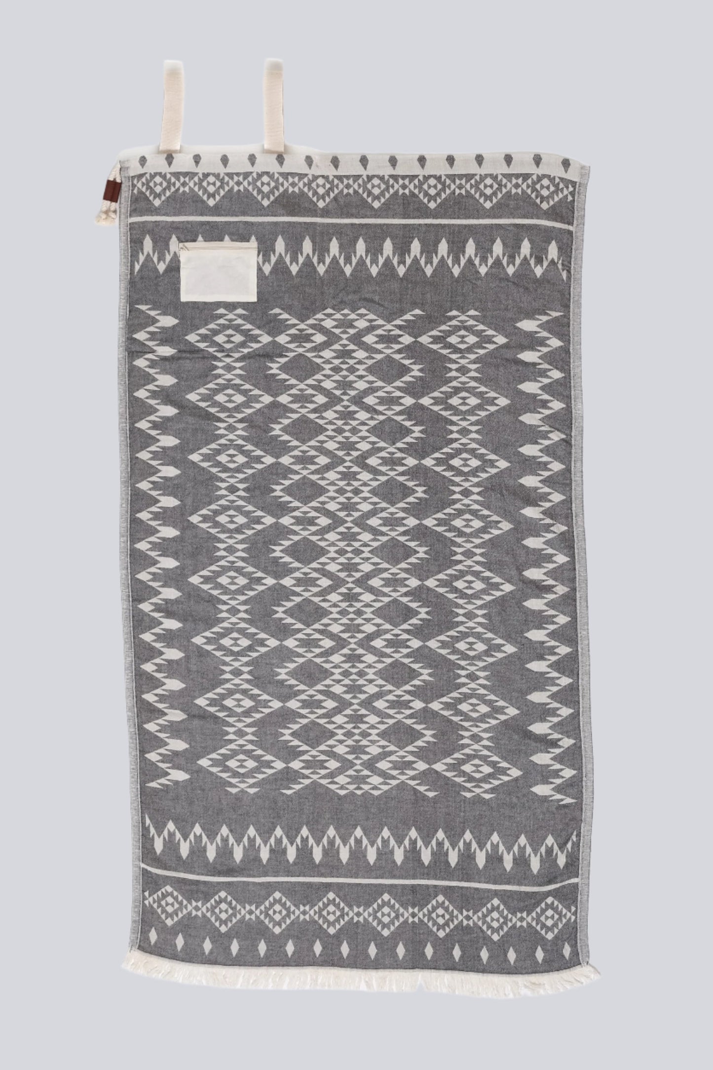 Granite with white side of the towel that accompanies - The Day Tripper Towel Backpack in Granite colour - on a white backdrop