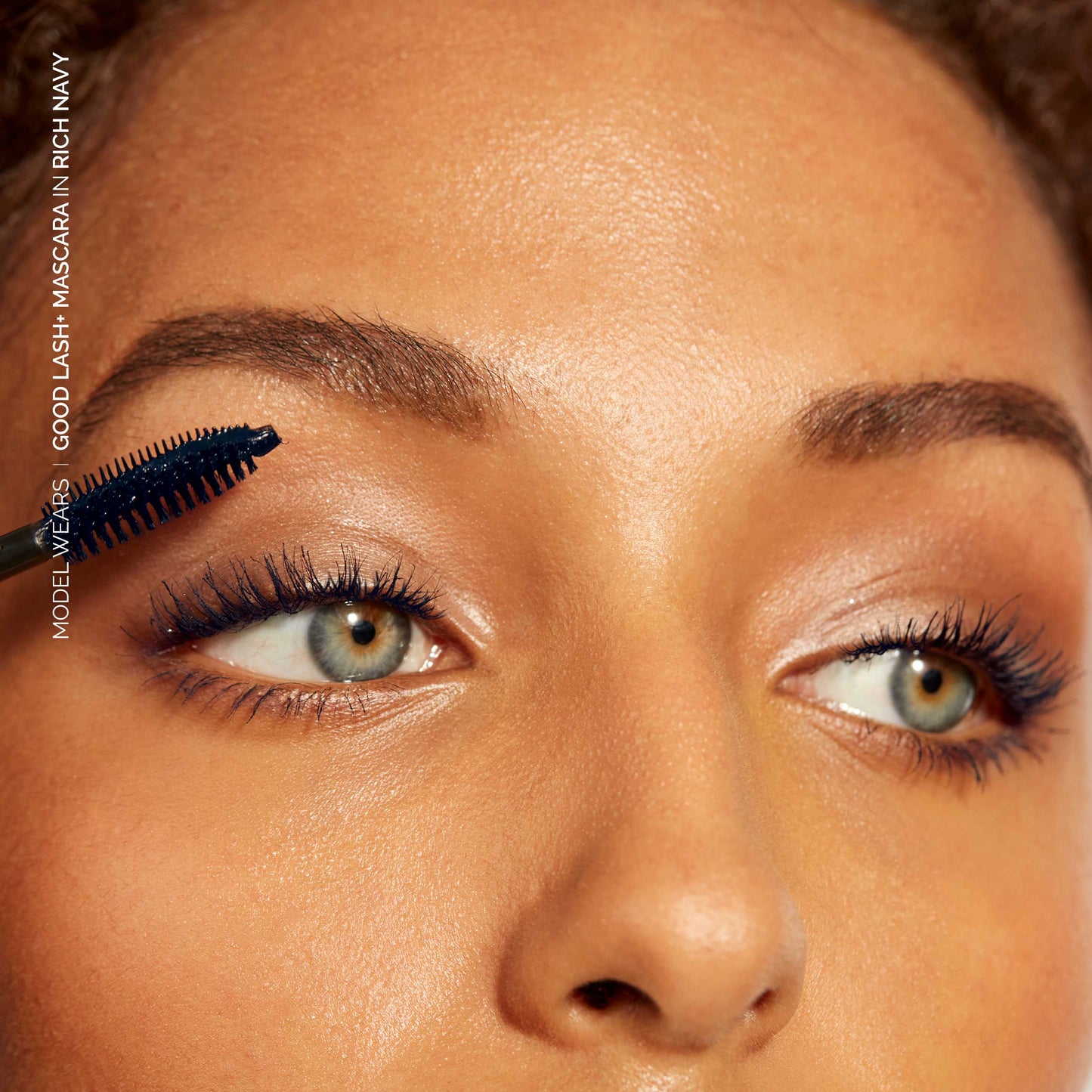 Close up of model applying Good Lash Mascara in Rich Nacy colour