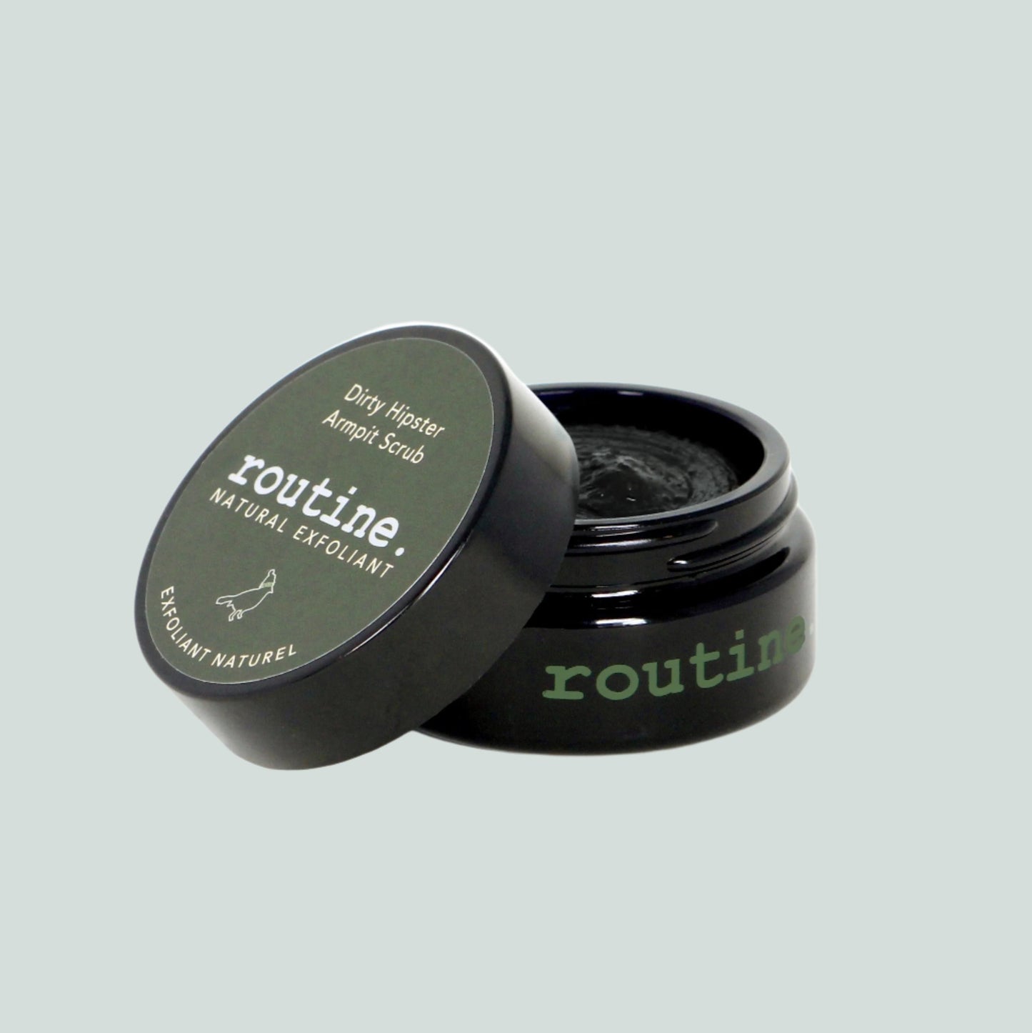 Forest Green Sticker on a Black Jar with a white bird. Open lid of Routine Natural Deodorant Cream - Dirty Hipster