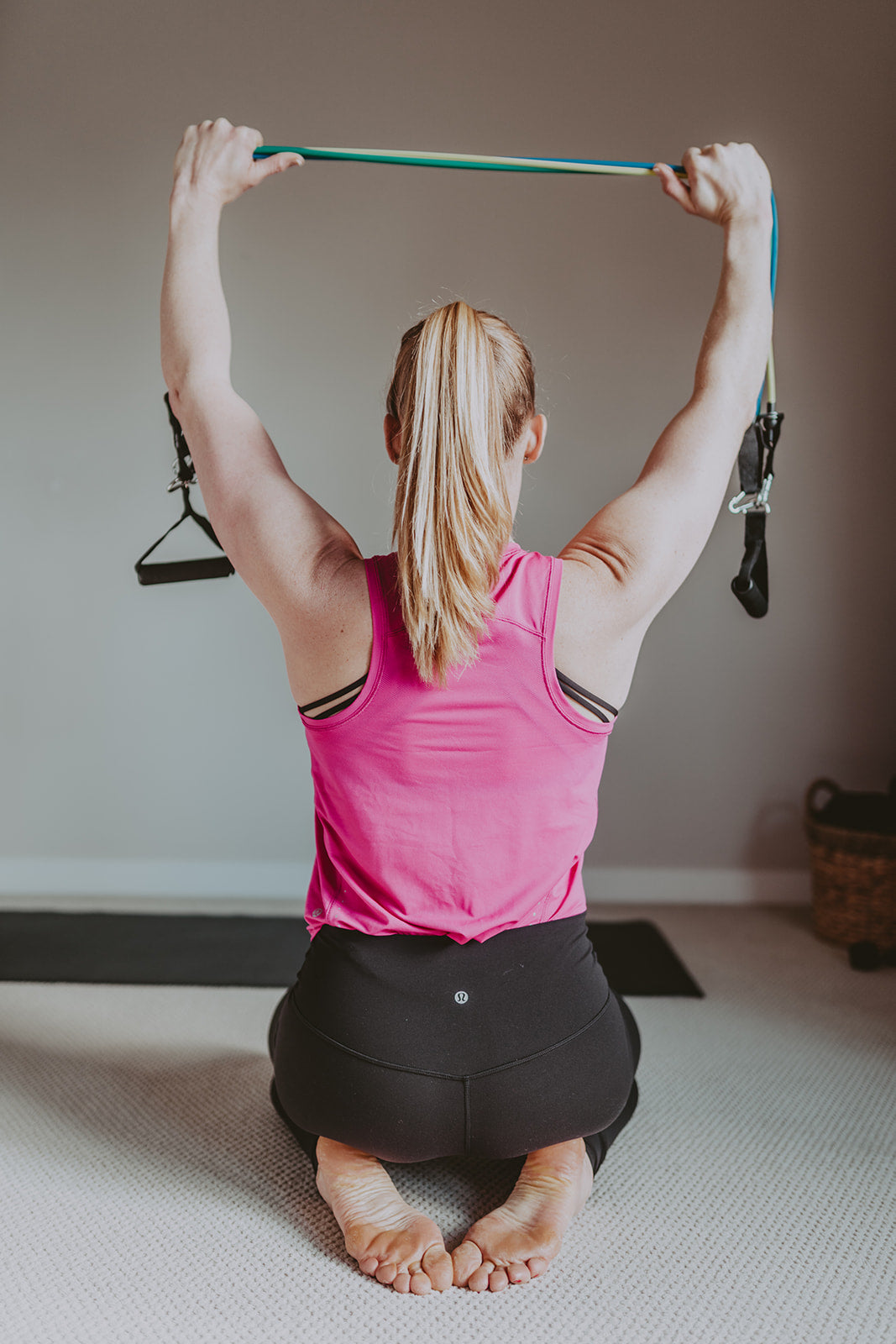 Photo of resistance band set in use - woman facing away with tension engaged on tubing