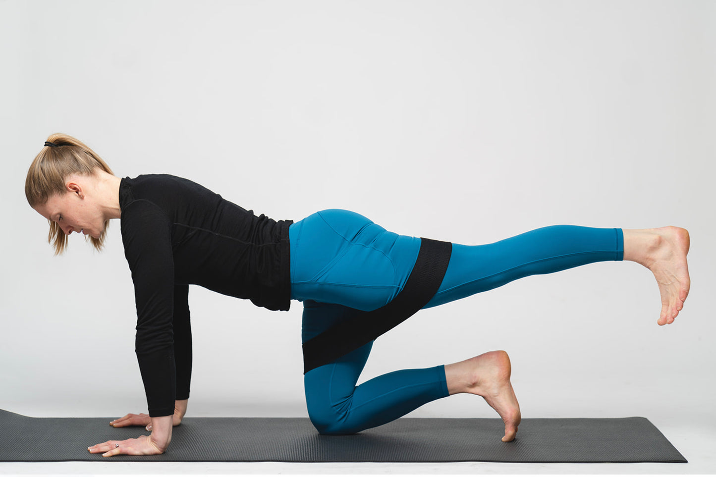 Black Resistance Band around a womans knees - used for kneeling press backs