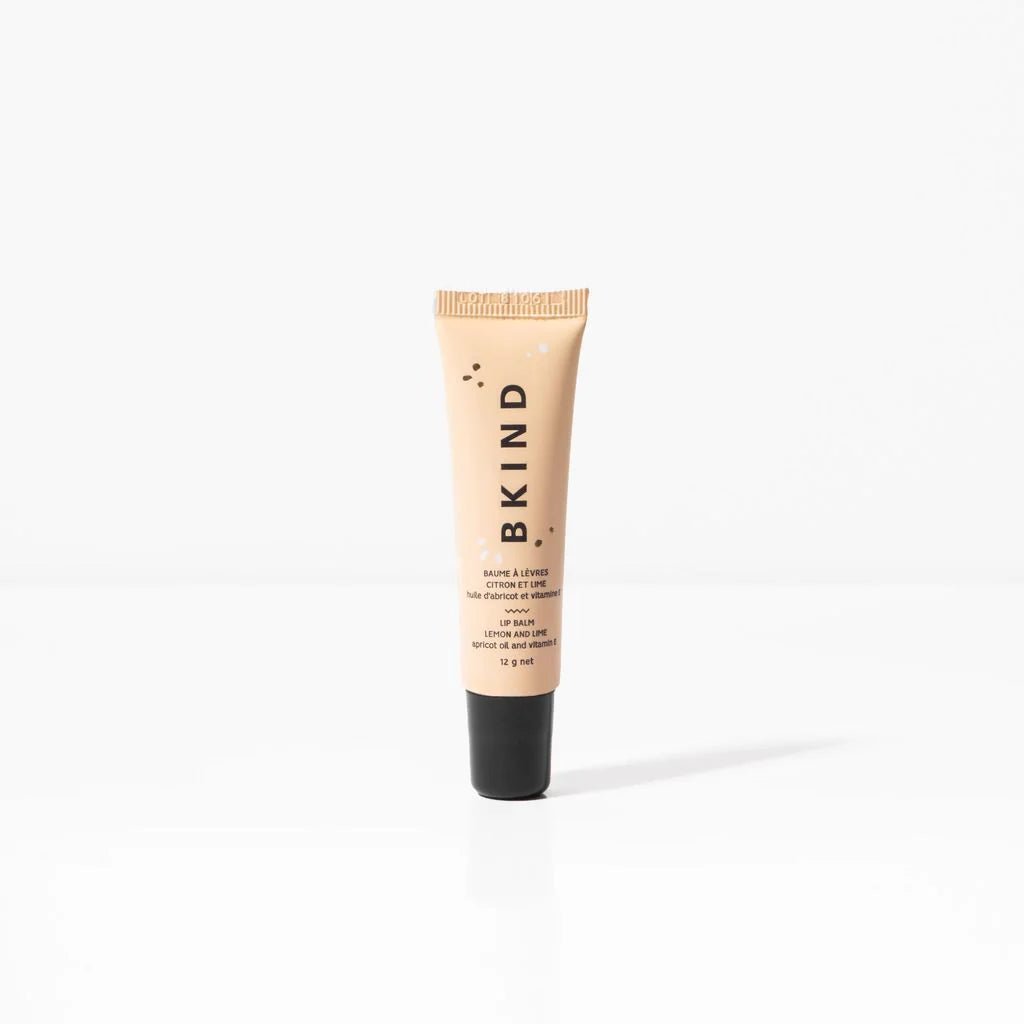 BKIND natural vegan lip balm - Lemon and Lime - Displayed on a white background  with a tube of peachy/beige BKIND lip balm with a black lid standing upright