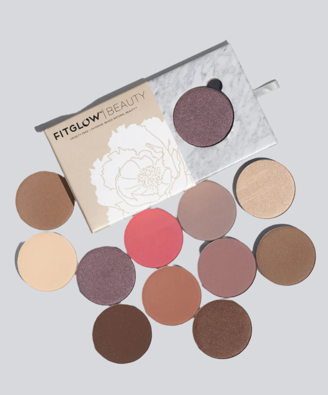 FITGLOW BEAUTY - multi use pressed shadow and blush - displayed with all 12 shades of round small palettes on a white clean background.
