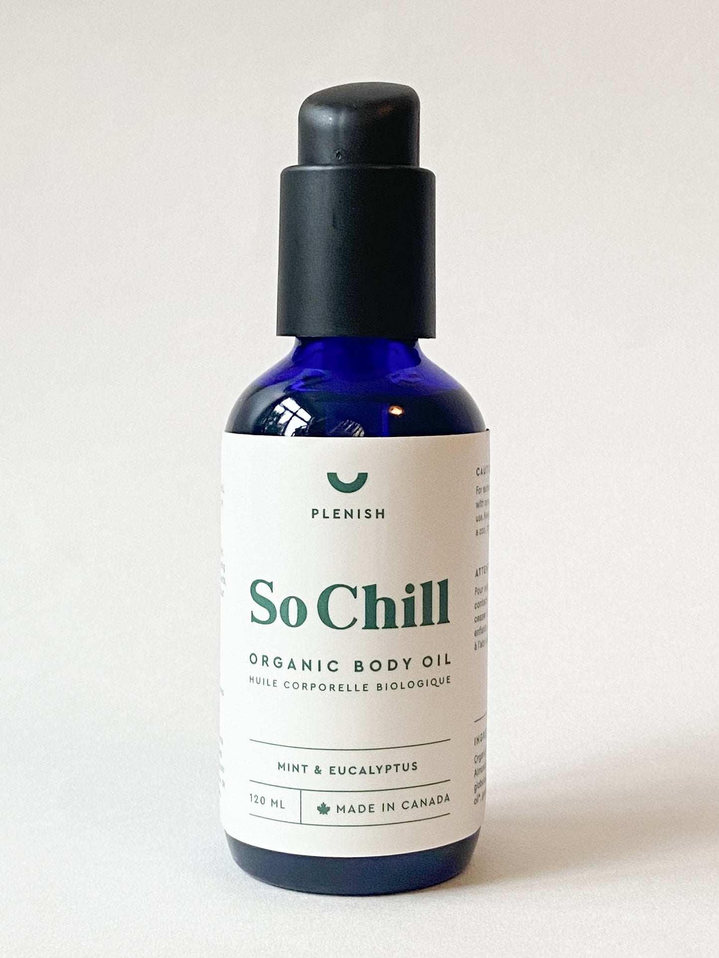 Bottle of 'So Chill' organic body oil on a light grey background with 'Plenish' branding.