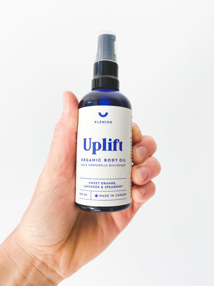 
                  
                    A photos of UPLIFT - Organic body oil, held in a hand - made in Canada 100mL of Sweet Orange, Lavender and Spearmint essential oils.
                  
                