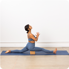 
                  
                    Woman using cork block in a yoga pose - supported splits. Charcoal mat and white background.
                  
                