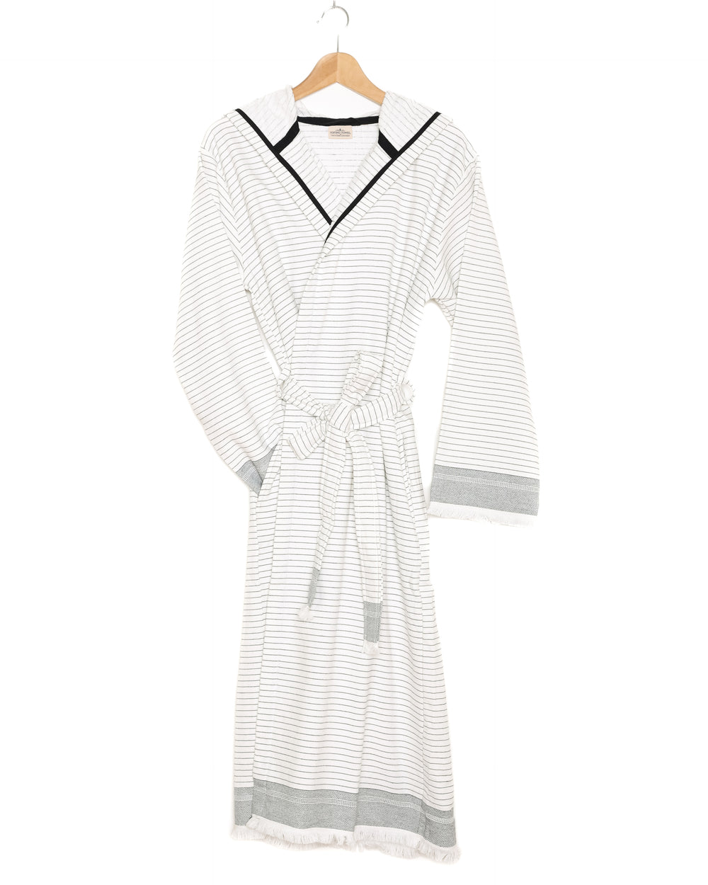 The Silas Robe from Tofino Towel Company - off white with black thin horizontal stripes and a hood.  Photographed on a wooden hanger on a white background.