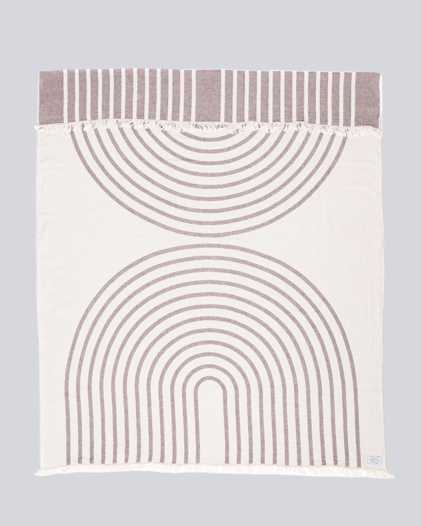 The Zen Throw by Tofino Towel Company - in white colour, a rainbow design with white and wine coloured accents.