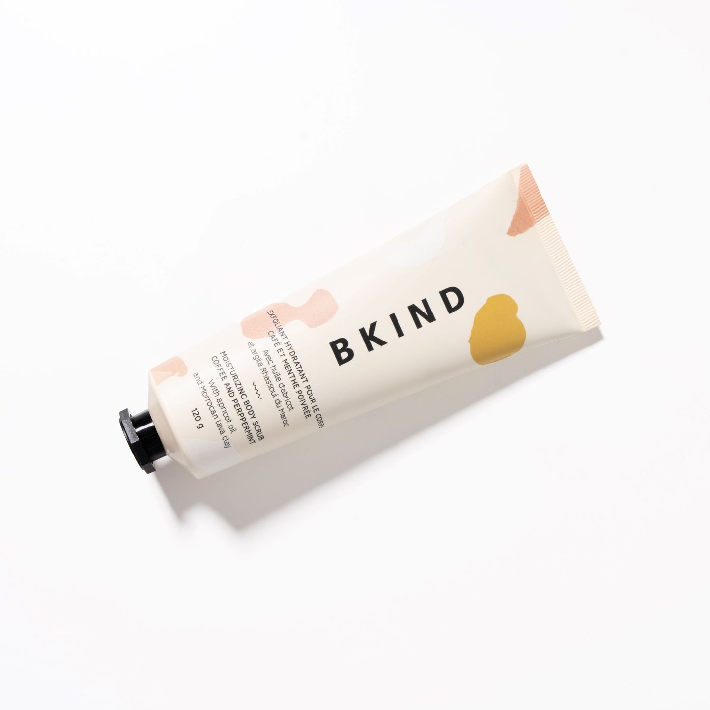 BKIND coffee and peppermint moisturizing scrub in a beige tube with peach designs on the tube displayed on a white background.
